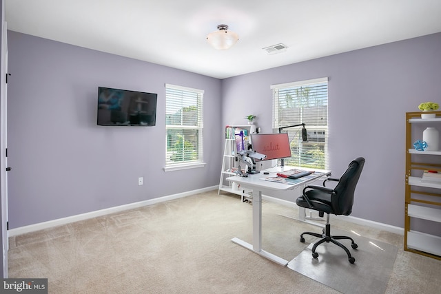 carpeted home office featuring baseboards, visible vents, and a healthy amount of sunlight