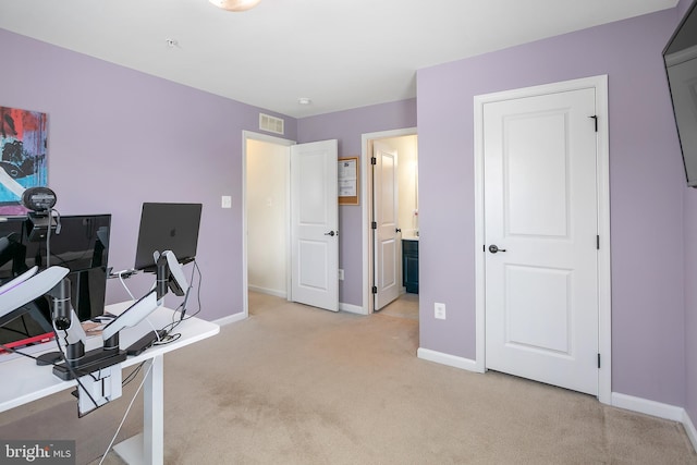 office area with visible vents, light carpet, and baseboards