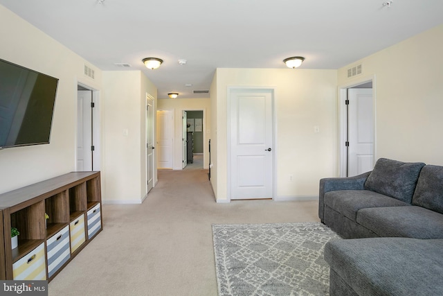 living room with visible vents, light carpet, and baseboards