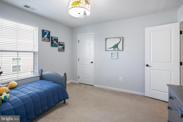 bedroom featuring visible vents, light carpet, and baseboards