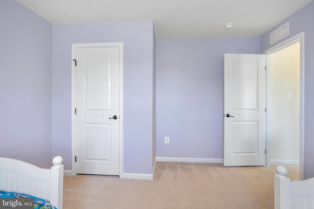 unfurnished bedroom with baseboards, visible vents, and light colored carpet