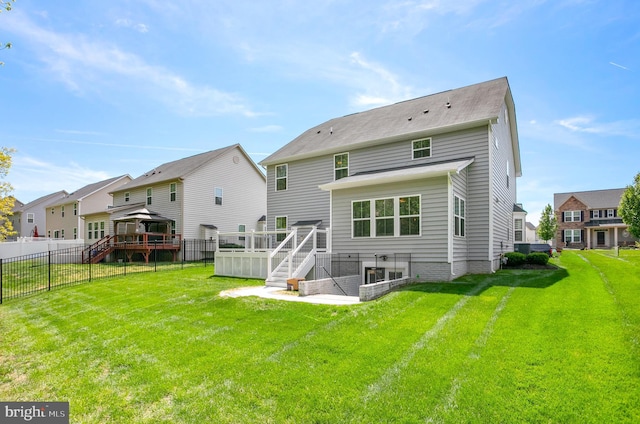 back of house with a residential view, a yard, a deck, a gazebo, and fence