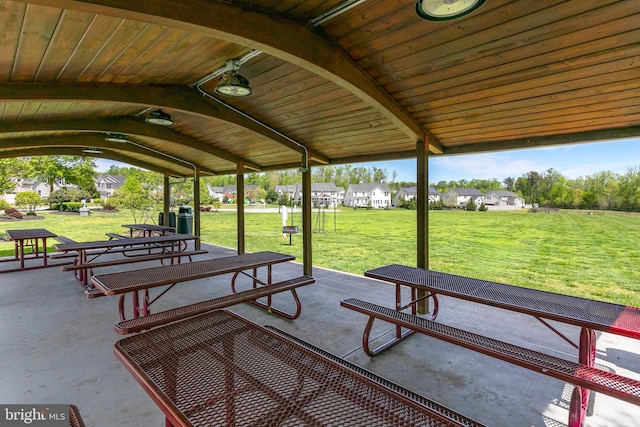 view of property's community featuring a residential view, a yard, and a patio area