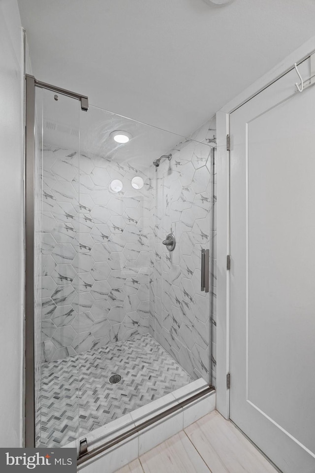 bathroom with a shower with door