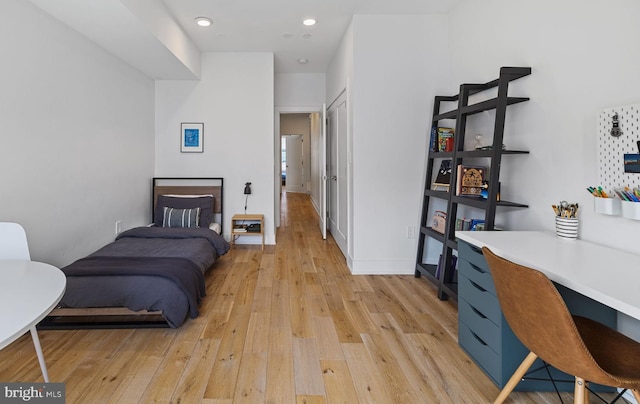 bedroom featuring light wood-type flooring and built in desk