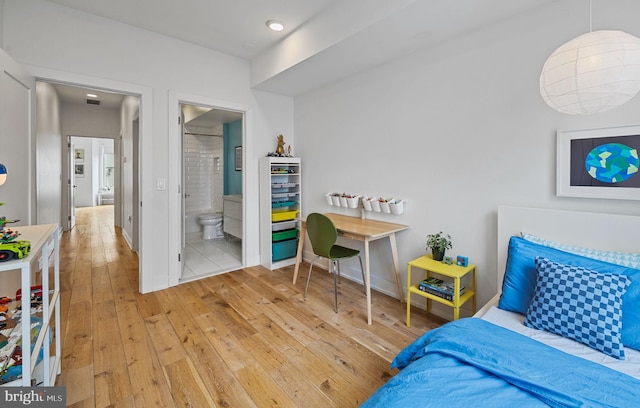 bedroom with ensuite bathroom and light wood-type flooring