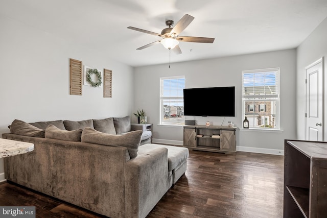 living room with baseboards, dark wood finished floors, and a ceiling fan