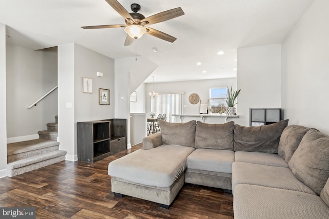 living room featuring baseboards, recessed lighting, dark wood-style flooring, stairs, and ceiling fan with notable chandelier