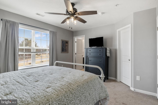 bedroom with light colored carpet, baseboards, visible vents, and ceiling fan