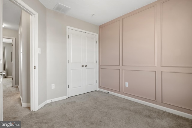 unfurnished bedroom with a closet, baseboards, visible vents, and carpet floors