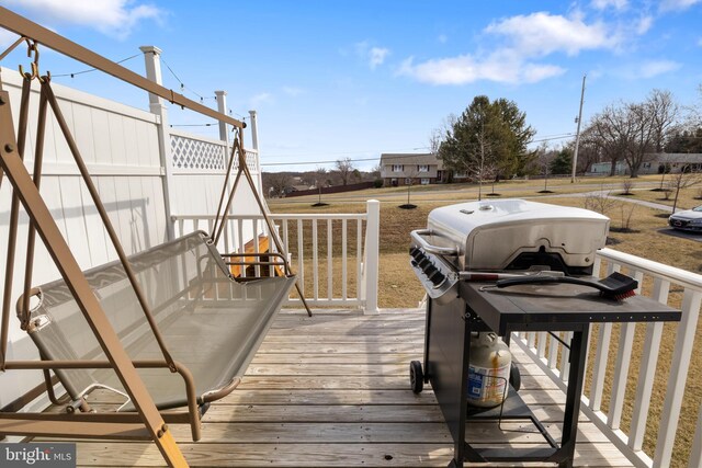 wooden deck with fence and a grill