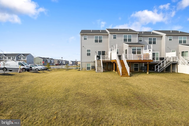 back of house with stairs, a deck, a yard, and a residential view