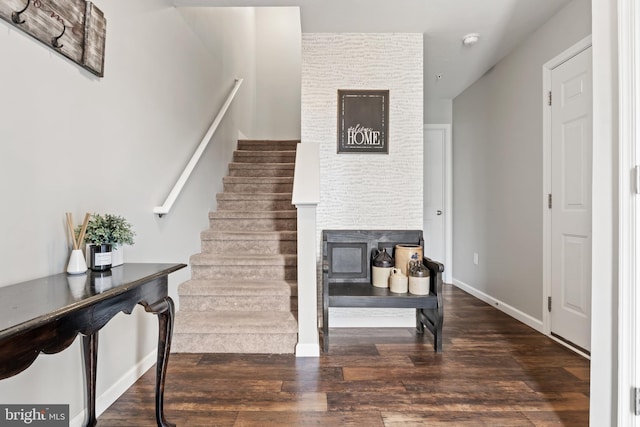 stairs with baseboards, wood finished floors, and a fireplace