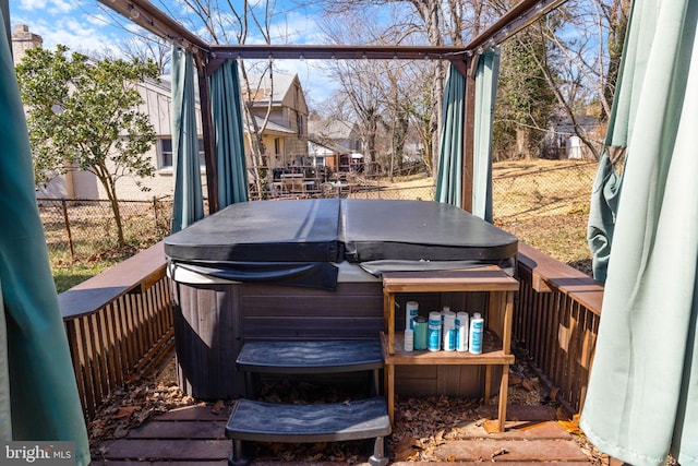 wooden terrace with a hot tub and fence