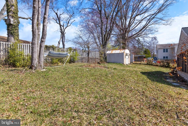 view of yard featuring a fenced backyard, a shed, and an outdoor structure