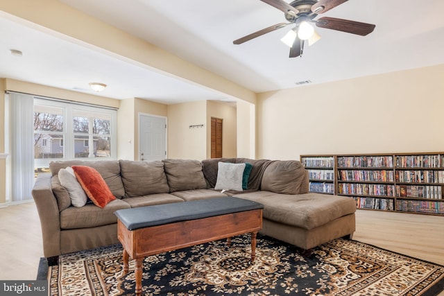 living area featuring ceiling fan, visible vents, and wood finished floors