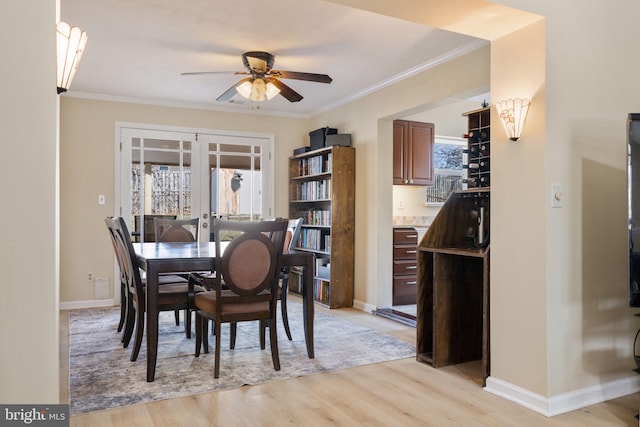 dining room featuring a ceiling fan, french doors, light wood finished floors, and ornamental molding