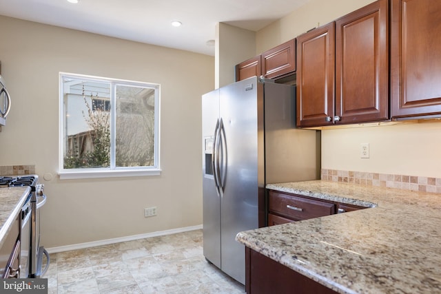 kitchen with recessed lighting, light stone counters, baseboards, and appliances with stainless steel finishes