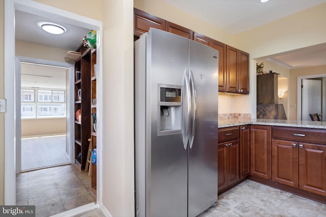 kitchen with light stone countertops and stainless steel fridge