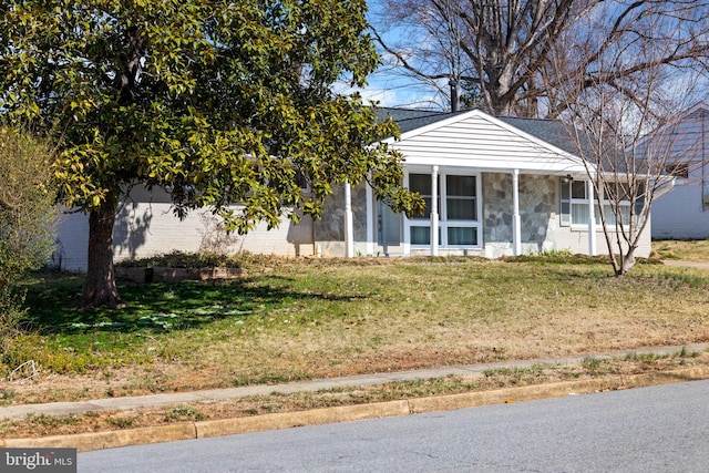 view of front of property with a front lawn and stone siding