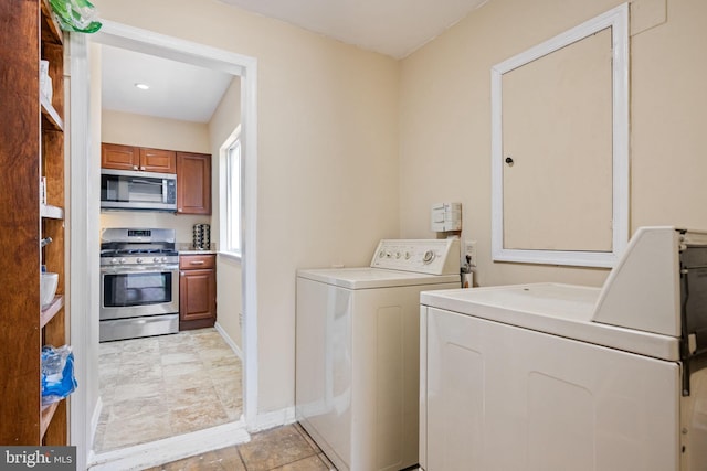 laundry area featuring baseboards, separate washer and dryer, and laundry area