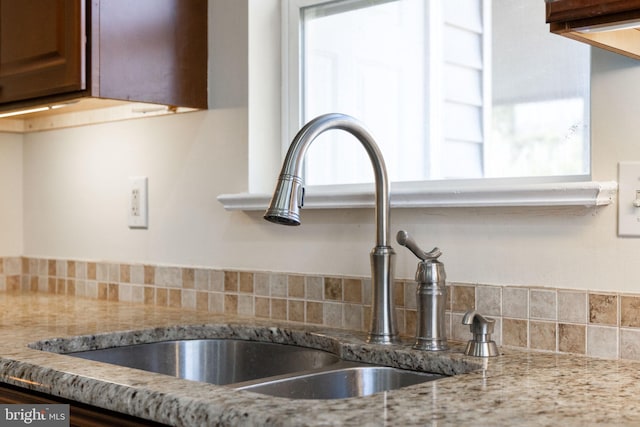 details featuring light stone countertops and a sink