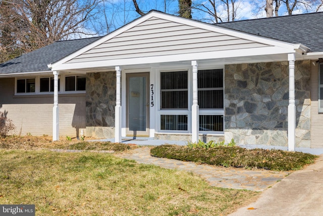 view of front of house with stone siding and a shingled roof