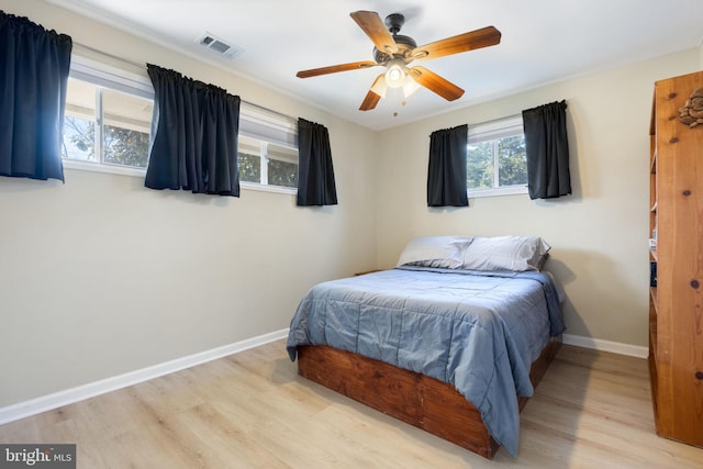 bedroom with visible vents, ceiling fan, baseboards, and wood finished floors