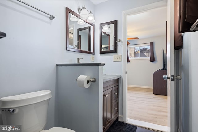 bathroom with vanity, toilet, and baseboards