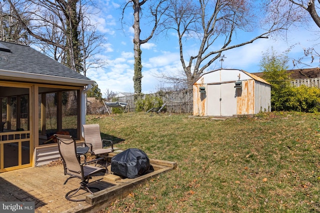 view of yard featuring an outbuilding, a sunroom, fence, and a shed