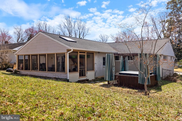 back of property featuring roof with shingles, a yard, a sunroom, a hot tub, and brick siding