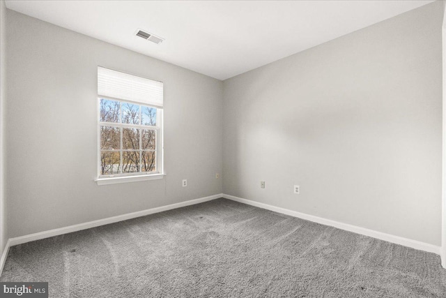 carpeted empty room with visible vents and baseboards