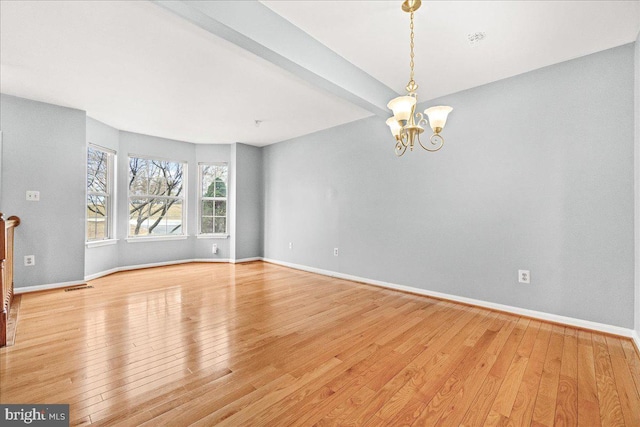 unfurnished living room featuring baseboards, visible vents, a notable chandelier, and light wood finished floors