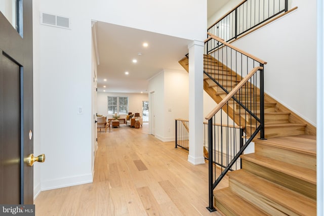 entryway with light wood-type flooring and crown molding