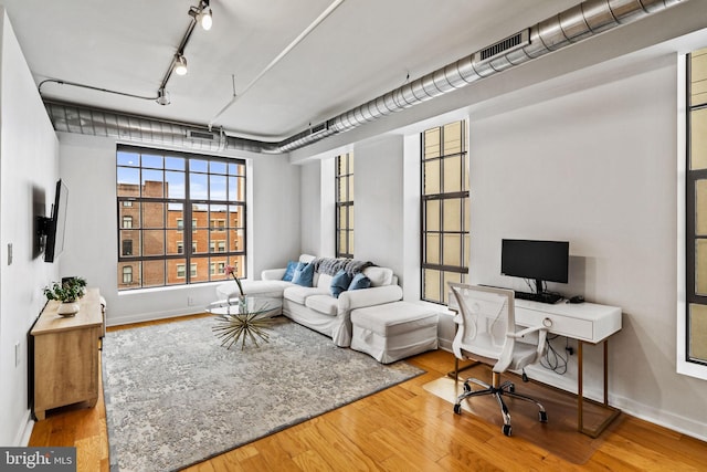 interior space with rail lighting, baseboards, and wood finished floors