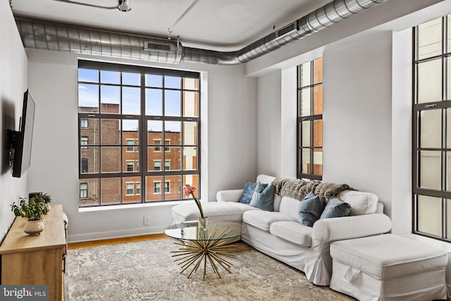 sitting room with baseboards, visible vents, and wood finished floors