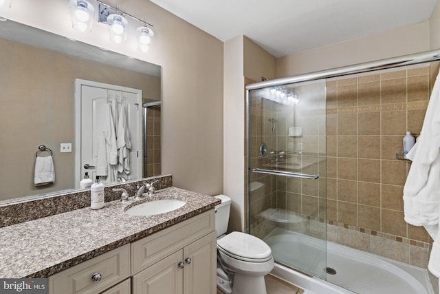 bathroom featuring toilet, a stall shower, and vanity