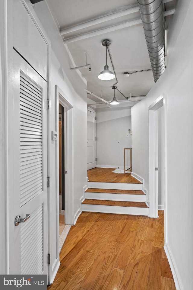 corridor with light wood finished floors and baseboards