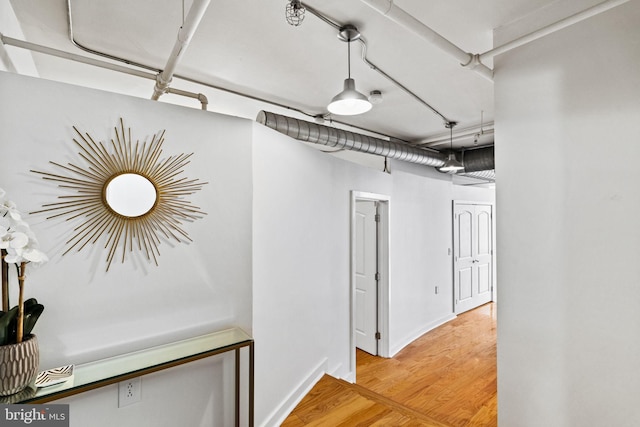 hallway with baseboards and wood finished floors