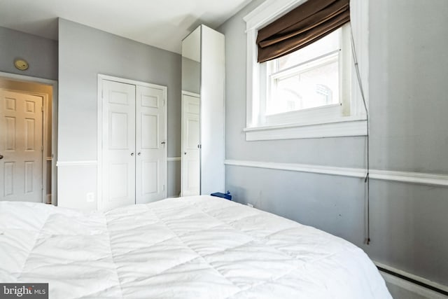 bedroom featuring a baseboard radiator and a closet