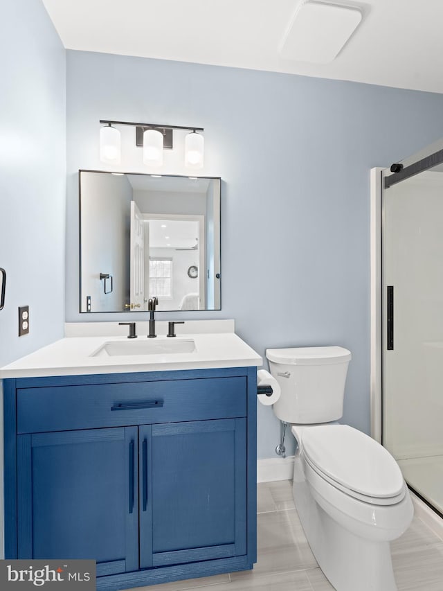 bathroom featuring a stall shower, vanity, and toilet