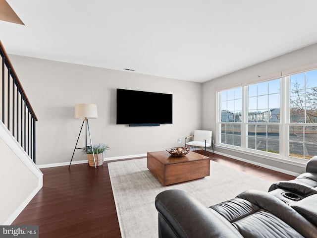 living area featuring visible vents, stairs, baseboards, and dark wood-style flooring