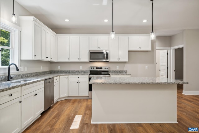 kitchen featuring sink, a kitchen island, hanging light fixtures, and stainless steel appliances