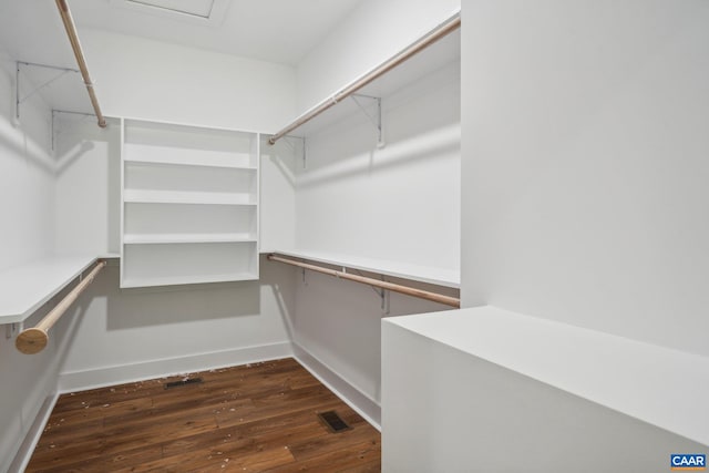 walk in closet with dark wood-type flooring