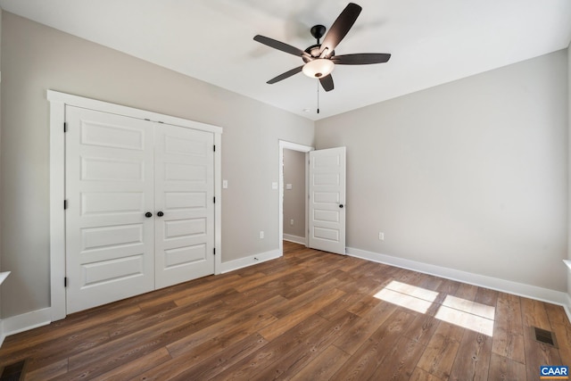 unfurnished bedroom with a closet, ceiling fan, and dark hardwood / wood-style floors