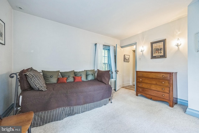 bedroom with light colored carpet and baseboards