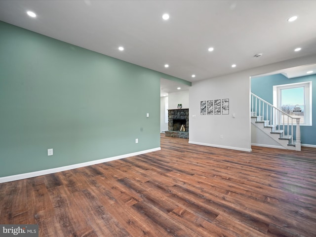 unfurnished living room featuring a fireplace and dark hardwood / wood-style floors