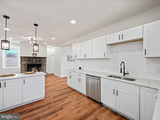 kitchen with white cabinets, pendant lighting, sink, and dishwasher