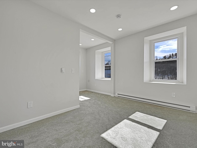 carpeted spare room featuring baseboard heating