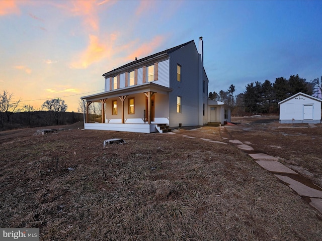 view of front of property with covered porch and a storage shed